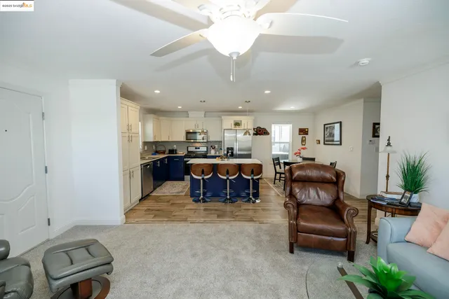 a living room with furniture and a dining table with kitchen view