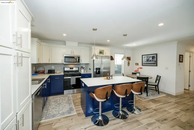 a kitchen with a dining table chairs and refrigerator