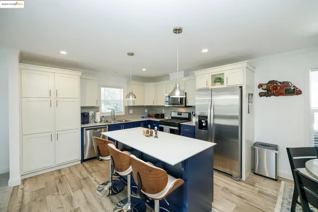 a kitchen with refrigerator and chairs