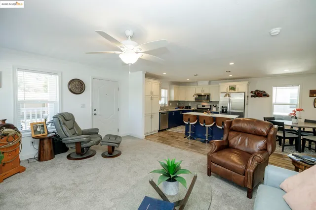 a living room with furniture kitchen view and a window