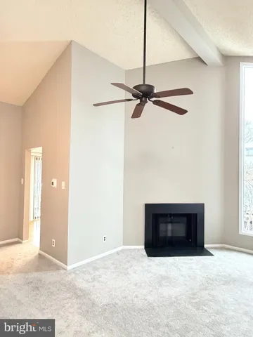 a view of an empty room with a fireplace and a window