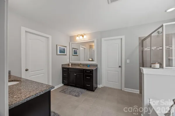 a spacious bathroom with a granite countertop sink mirror and shower