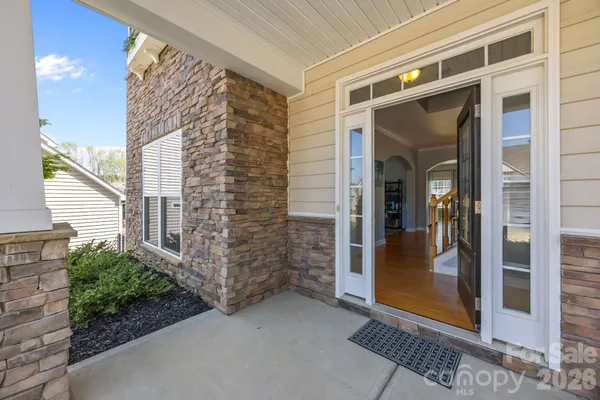 a view of front door and bedroom with wooden floor