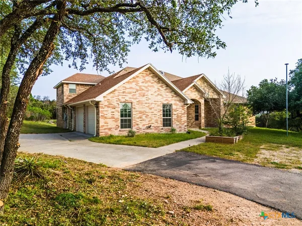 a view of a house with a yard and large tree