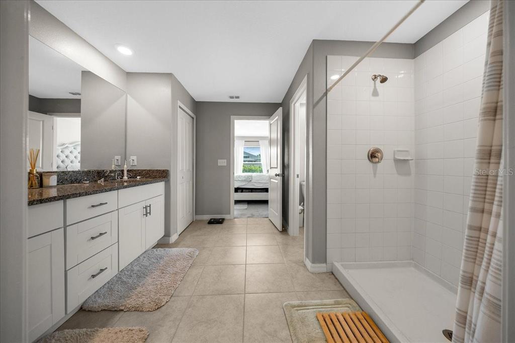 9329 Southwest 57th Terrace Ocala, FL 34476 - Photo 29 of 64 a bathroom with a glass door shower a sink and a mirror