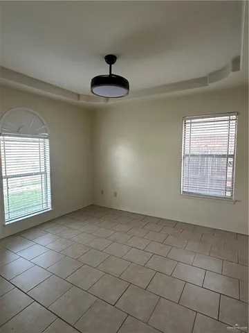 an empty room with a ceiling fan and window