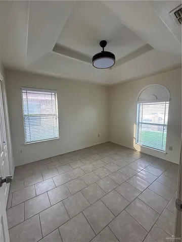 an empty room with a ceiling fan and window