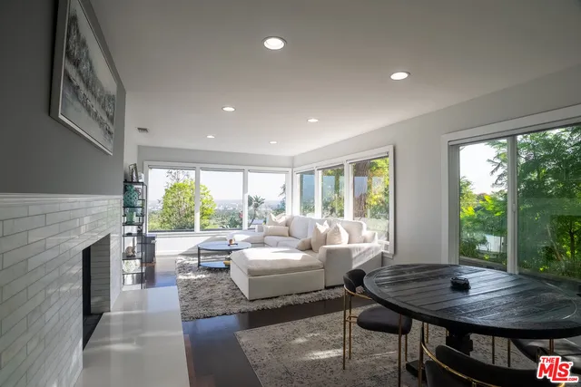 a living room with fireplace furniture and a large window