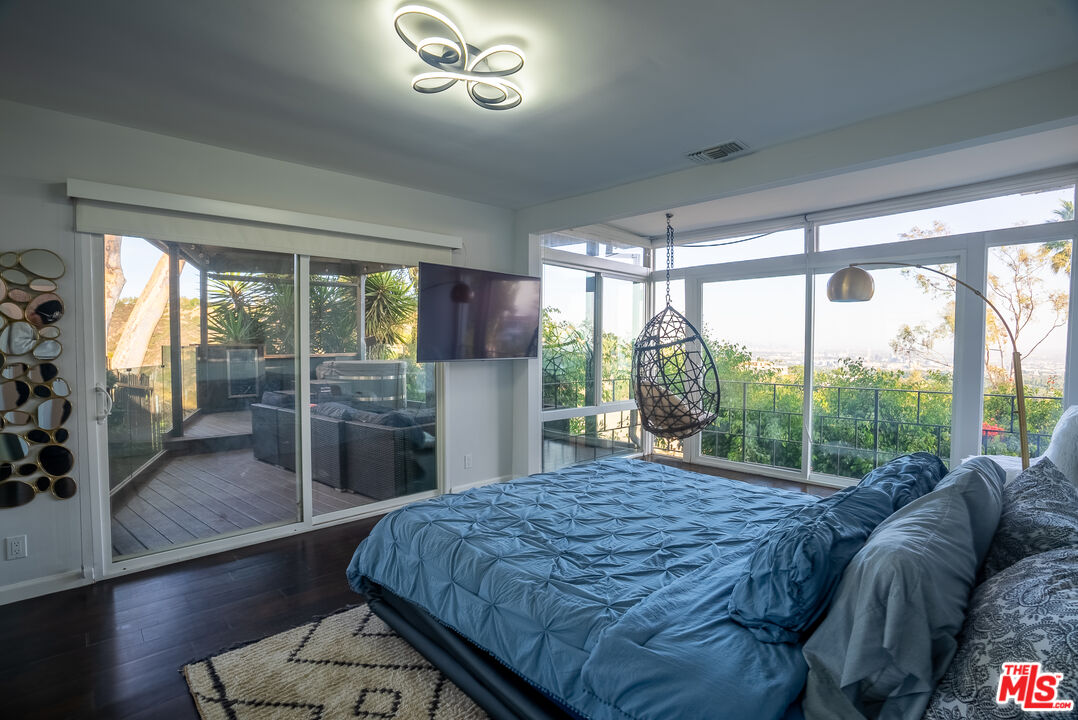 1438 Davies Drive Beverly Hills, CA 90210 - Photo 6 of 16 a bedroom with a bed and a large window with balcony view