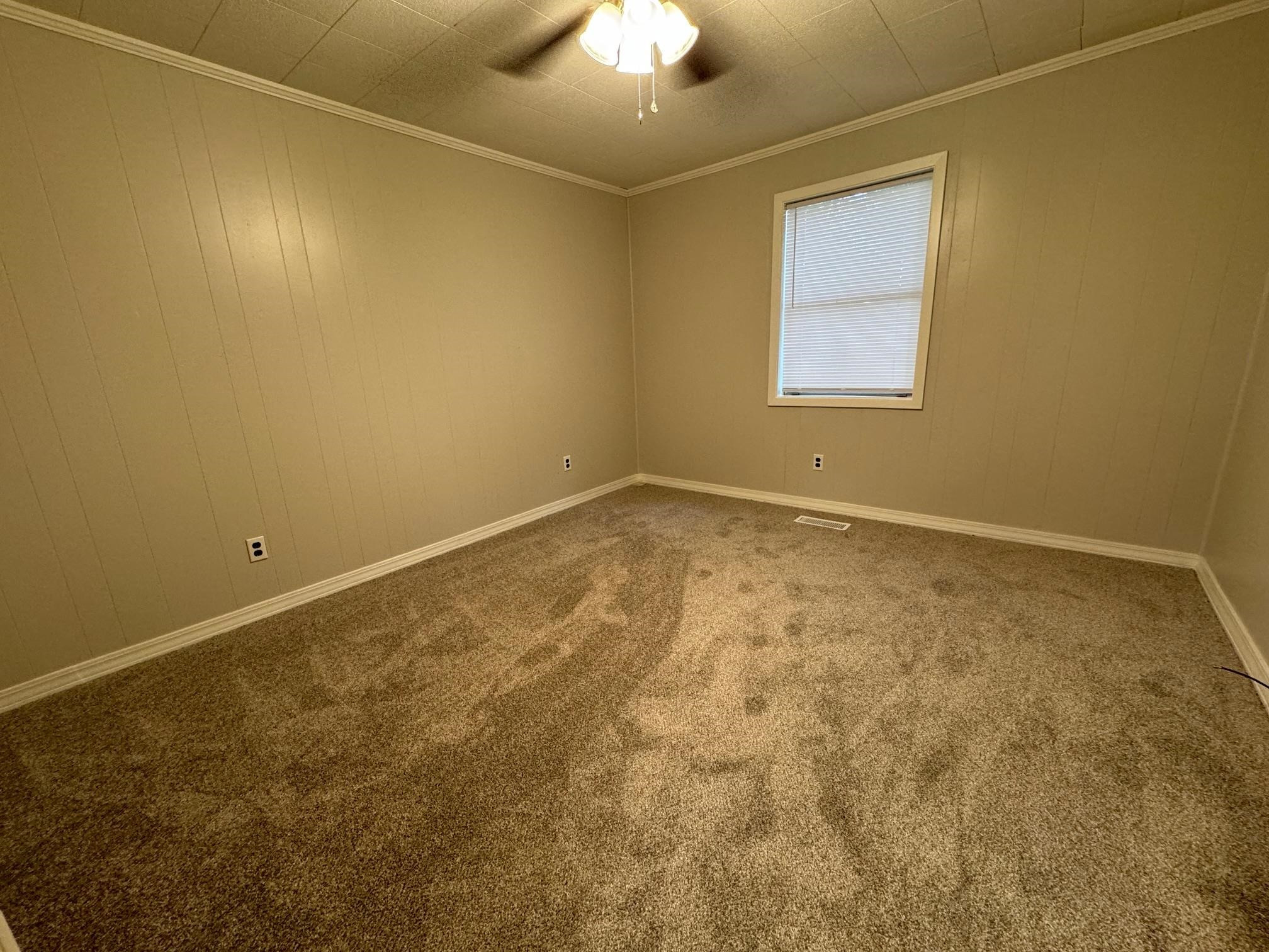323 Easley Road Newbern, TN 38059 - Photo 7 of 13 an empty room with a chandelier fan and windows