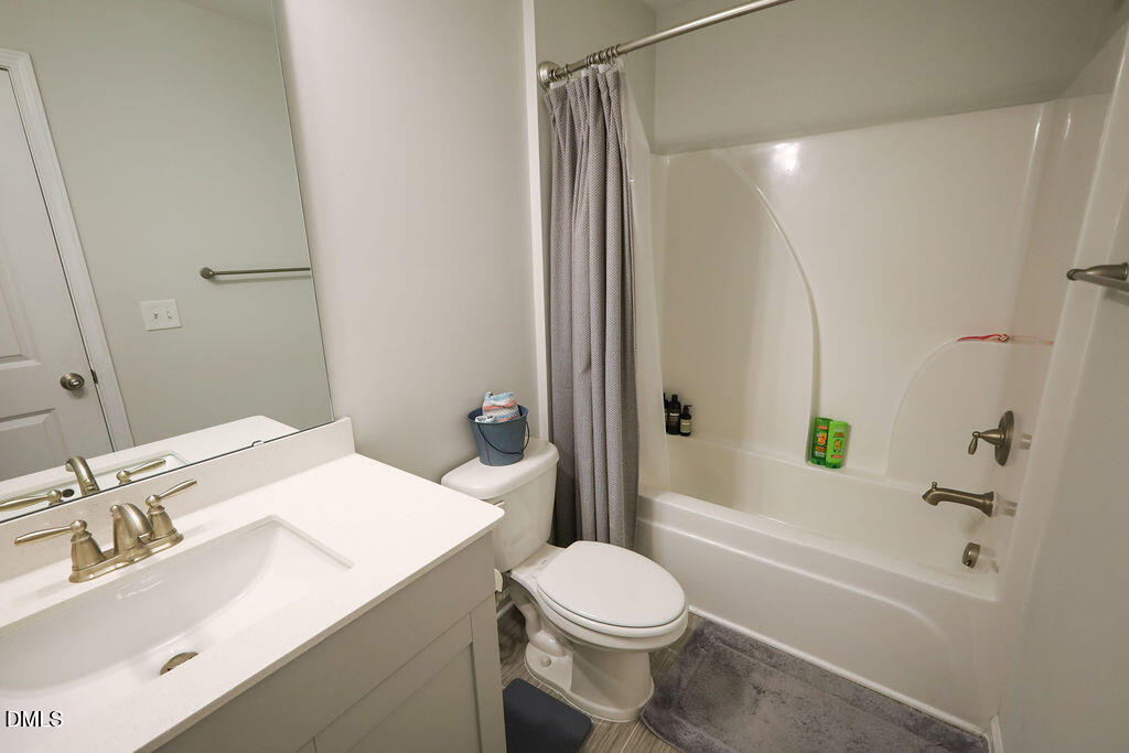 230 South Raleigh Street Angier, NC 27501 - Photo 29 of 38 a bathroom with a sink toilet vanity and shower