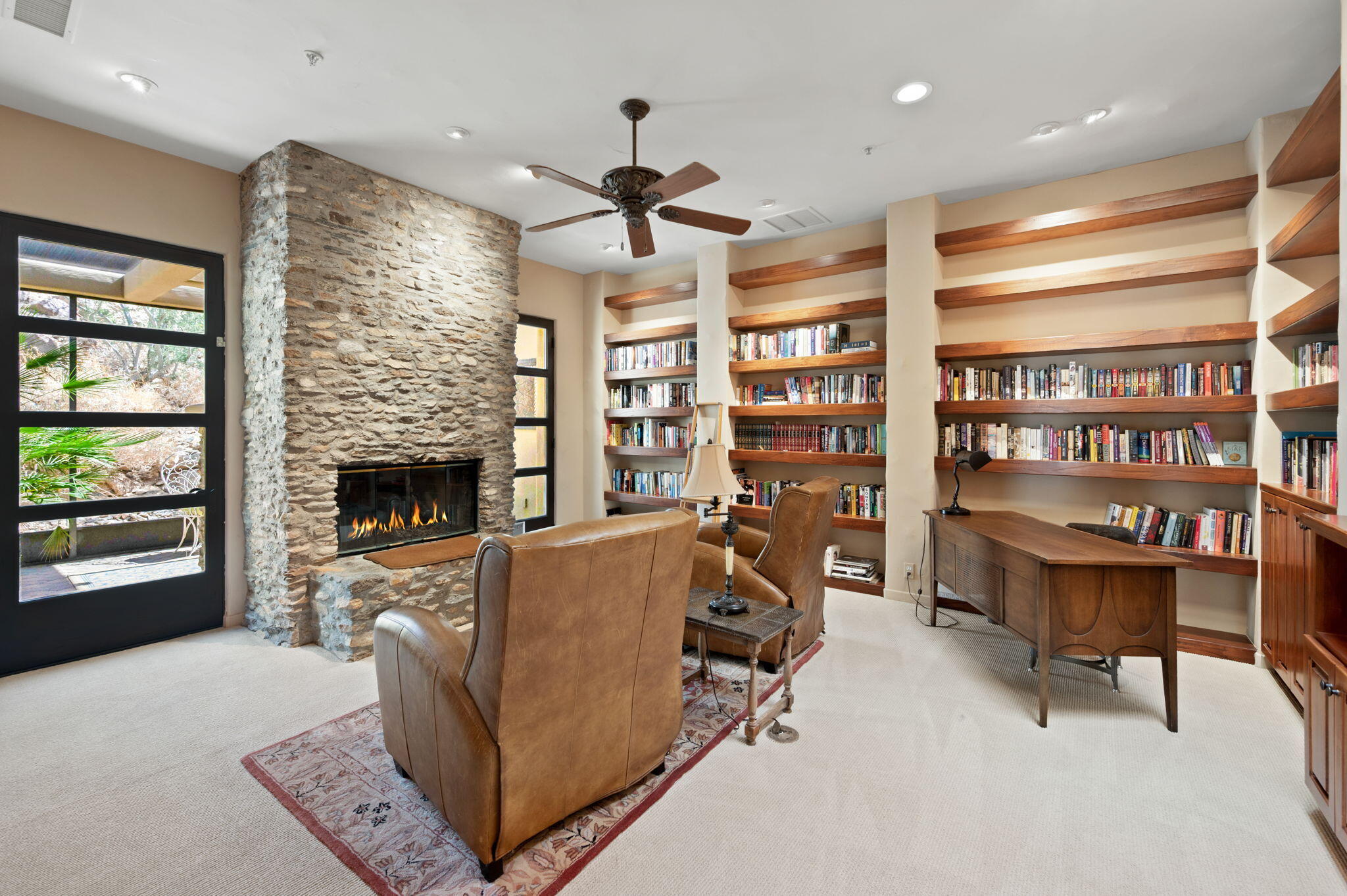 72275 Upper Way West Palm Desert, CA 92260 - Photo 35 of 68 a living room with furniture a fireplace and a book shelf