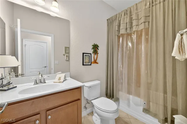 a bathroom with a sink a toilet and shower curtain