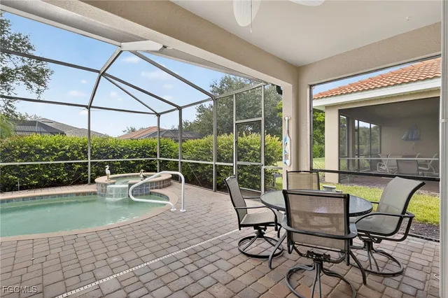 a view of a swimming pool with chair and table in the patio
