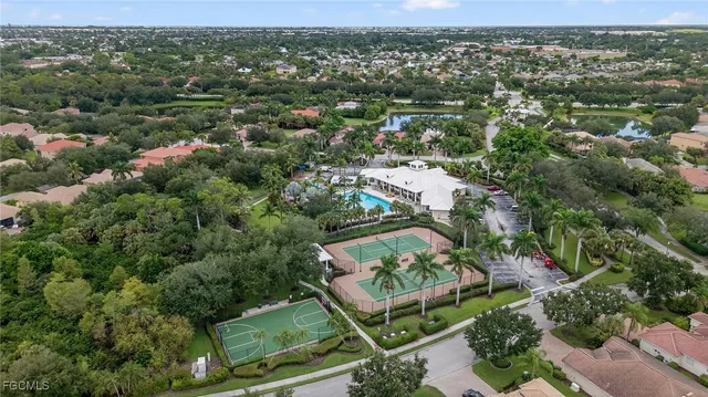 an aerial view of residential houses with outdoor space and trees