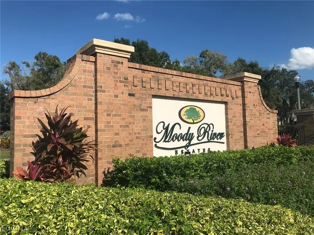 a sign that is sitting on a brick wall