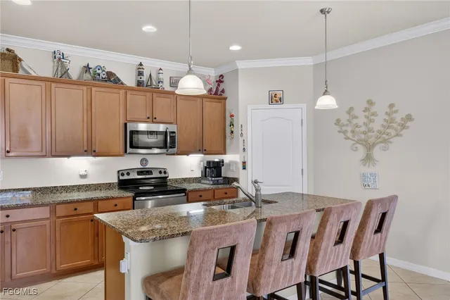 a kitchen with kitchen island granite countertop a sink a center island a stove and cabinets
