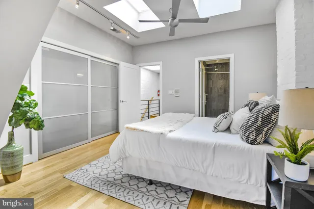 a bedroom with a large bed and a potted plant