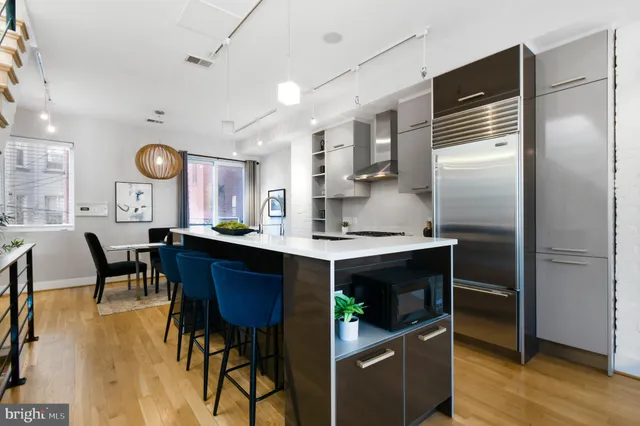 a kitchen that has a lot of cabinets stainless steel appliances and a sink