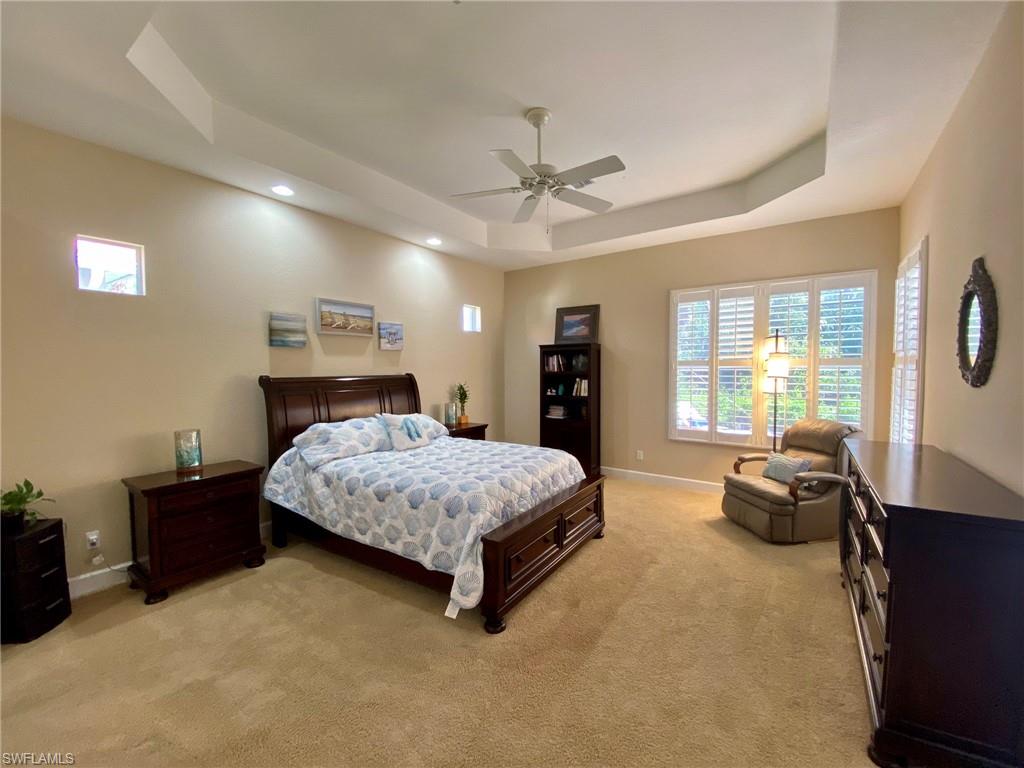 7806 Founders Circle Naples, FL 34104 - Photo 12 of 28 a spacious bedroom with a bed and a chandelier