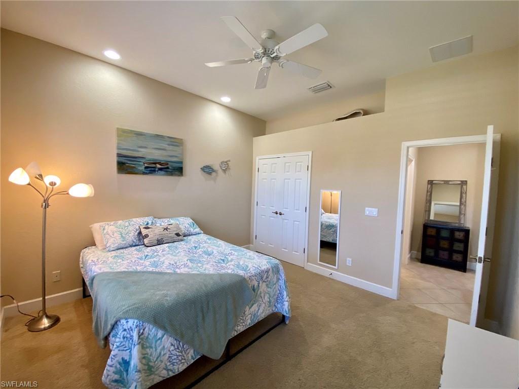 7806 Founders Circle Naples, FL 34104 - Photo 18 of 28 a bedroom with a bed and a chandelier