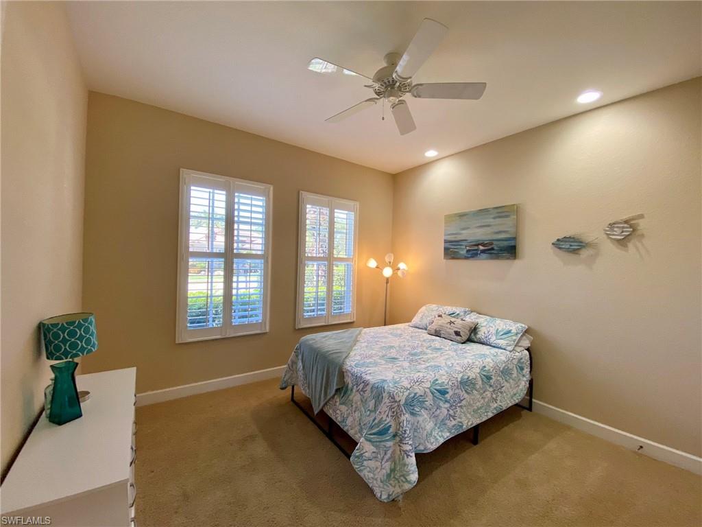 7806 Founders Circle Naples, FL 34104 - Photo 19 of 28 a bedroom with a bed chandelier and window