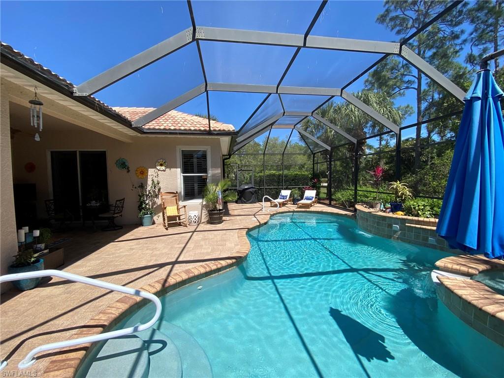 7806 Founders Circle Naples, FL 34104 - Photo 24 of 28 a view of a patio with dining table and chairs under an umbrella