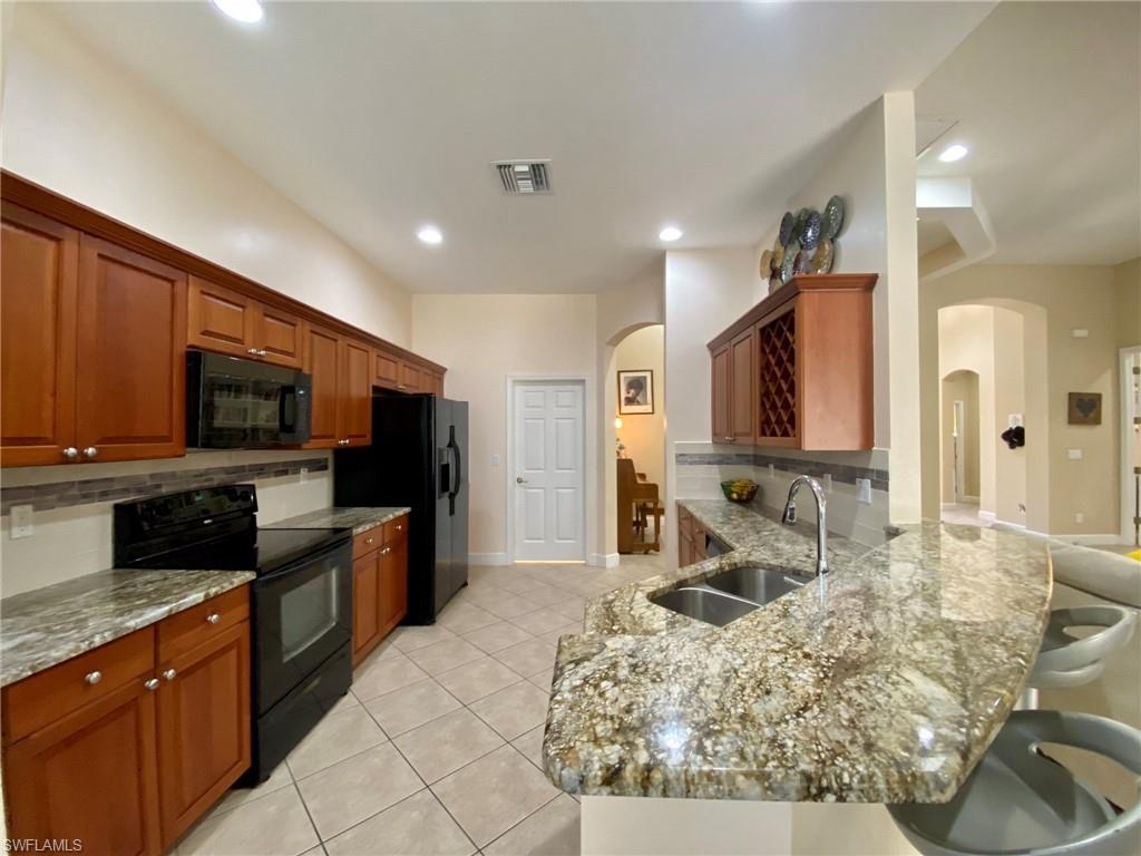 7806 Founders Circle Naples, FL 34104 - Photo 8 of 28 a large kitchen with stainless steel appliances granite countertop a large counter top cabinets and a sink