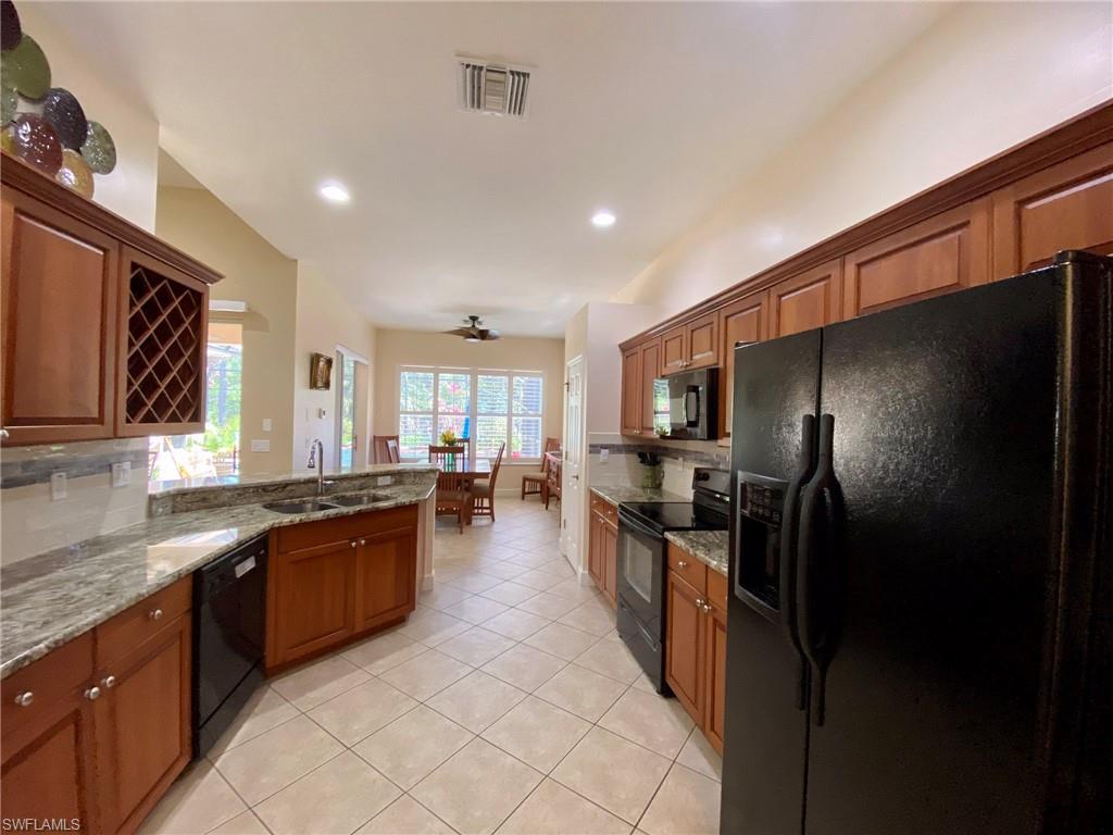 7806 Founders Circle Naples, FL 34104 - Photo 9 of 28 a large kitchen with granite countertop lots of counter space and stainless steel appliances