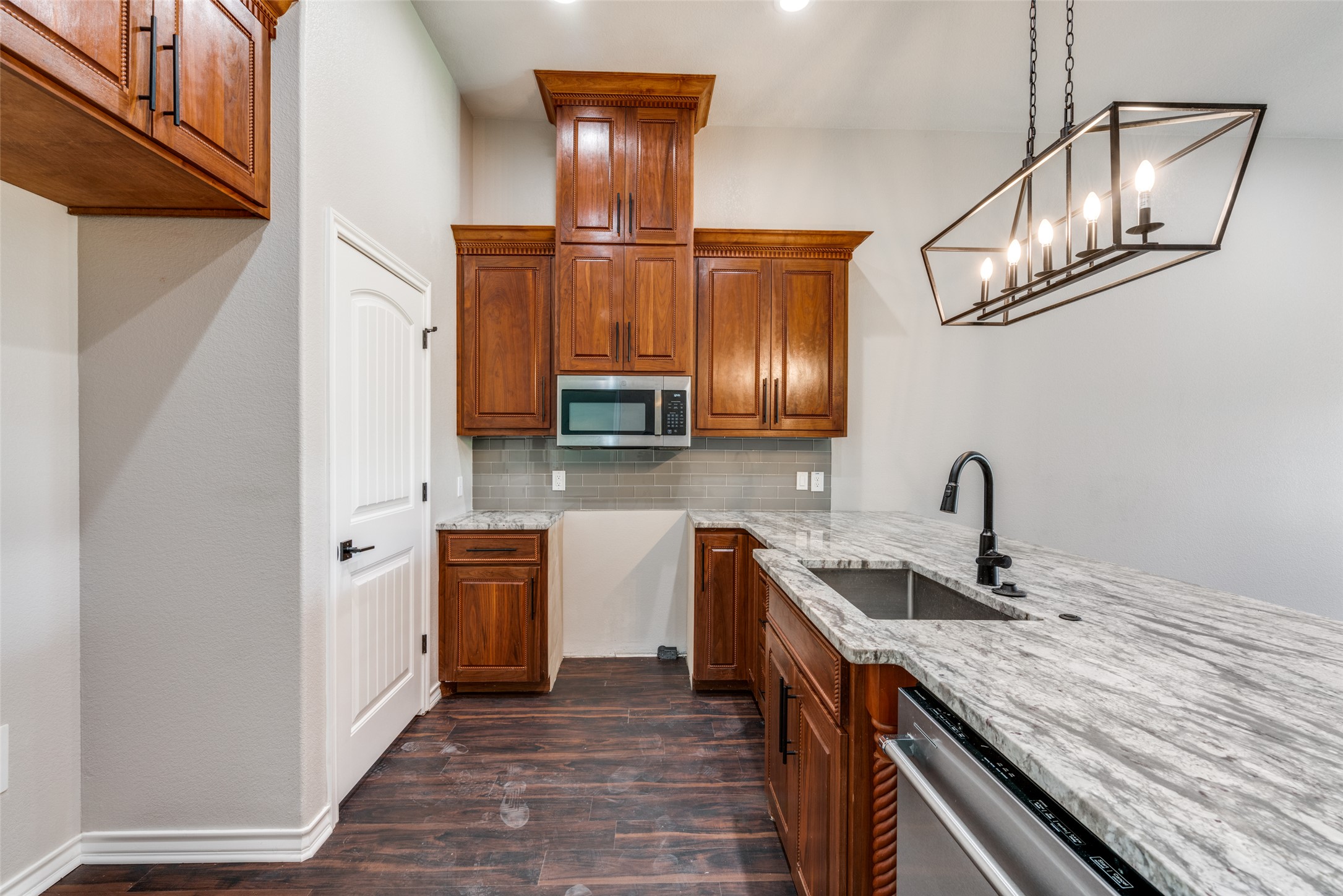 301 Navarro Way, Unit 29B Seguin, TX 78155 - Photo 2 of 26 a kitchen with stainless steel appliances granite countertop a sink and dishwasher a stove top oven with wooden floor