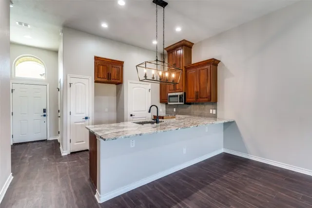 a view of living room with granite countertop wooden floor and ceiling fan