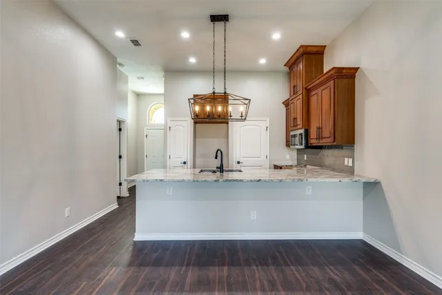 a view of a kitchen with kitchen island a sink wooden floor and window
