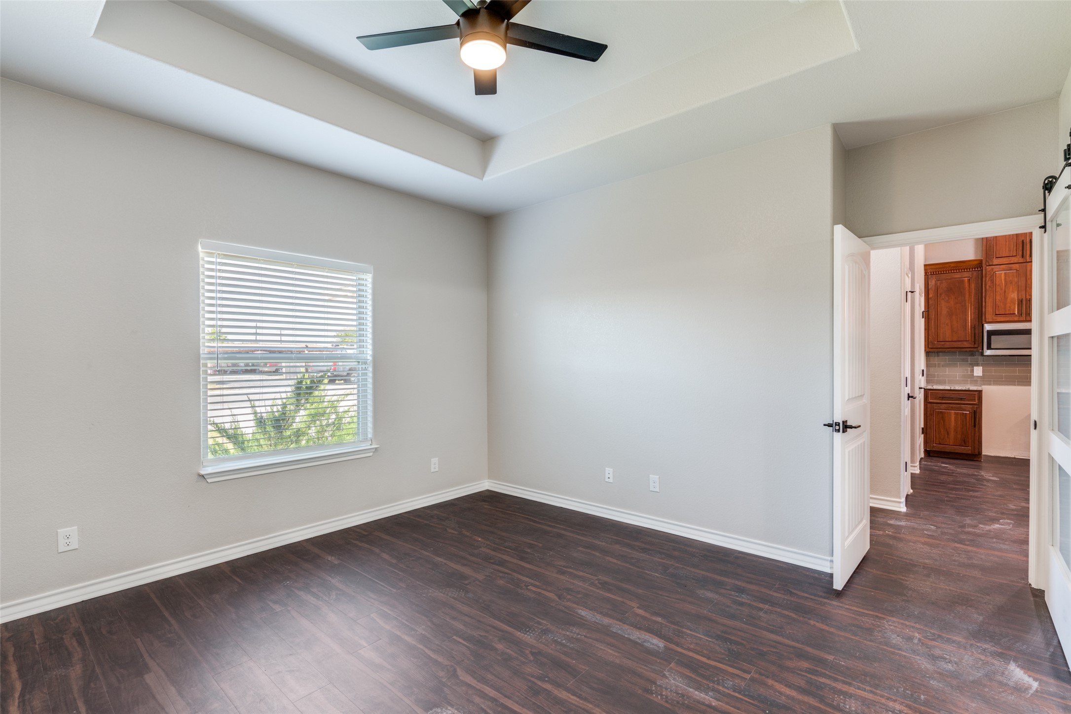 301 Navarro Way, Unit 29B Seguin, TX 78155 - Photo 7 of 26 an empty room with wooden floor a ceiling fan and windows