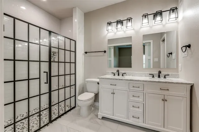 a bathroom with a double vanity sink a toilet and a mirror