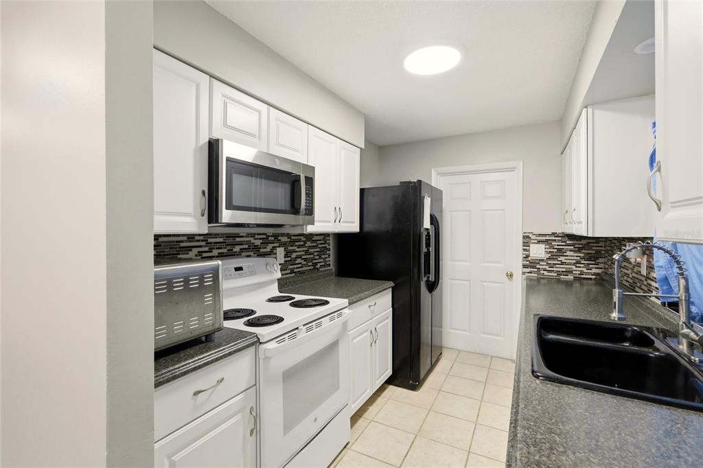 301 Lambert Street Port Charlotte, FL 33948 - Photo 8 of 30 a kitchen with a refrigerator stove and microwave