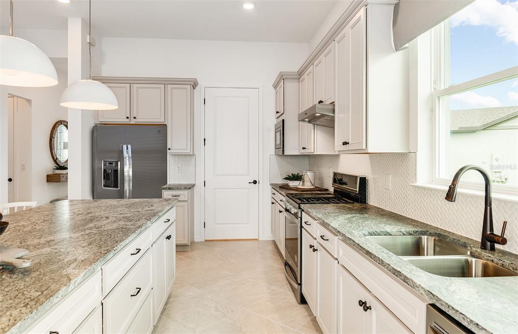 1947 Spring Shower Circle Kissimmee, FL 34744 - Photo 5 of 18 a kitchen with stainless steel appliances granite countertop a sink a stove and refrigerator