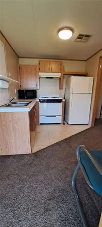 a living room with stainless steel appliances furniture and a rug