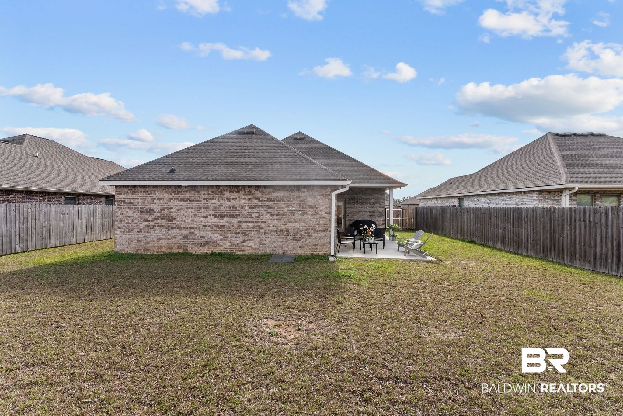 10745 Brodick Loop Daphne, AL 36527 - Photo 27 of 39 Back of house featuring brick siding, a patio, a fenced backyard, and a shingled roof