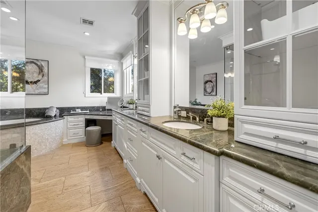a bathroom with a granite countertop sink and a mirror