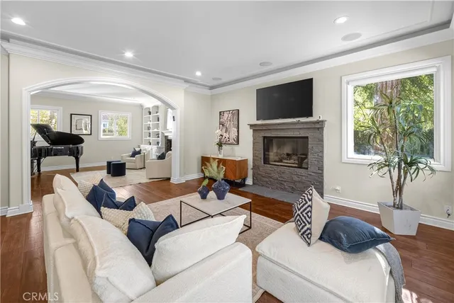 a living room with furniture a large window and a fireplace