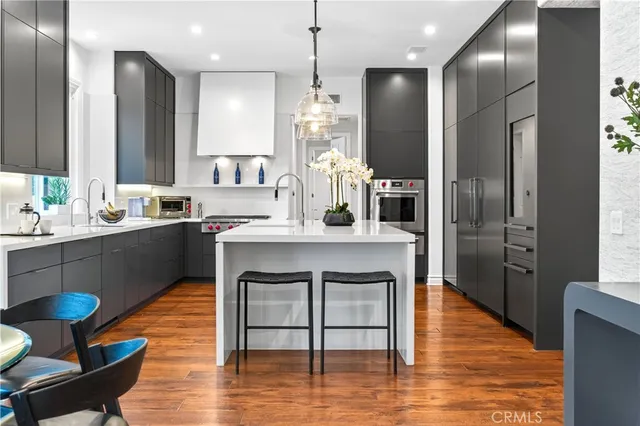 a kitchen with kitchen island granite countertop a sink cabinets and wooden floor