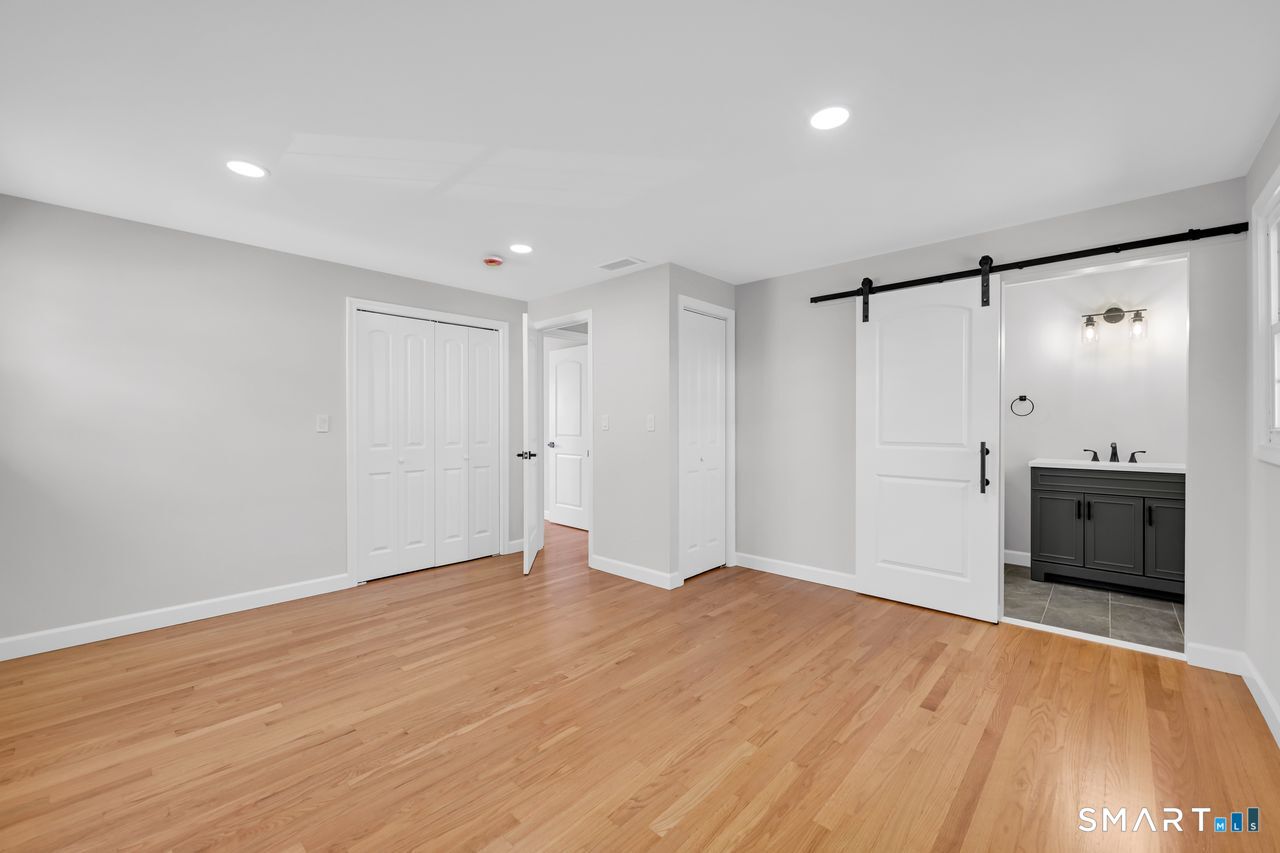 129 Midwell Road Wethersfield, CT 06109 - Photo 13 of 28 Spacious primary bedroom with a stunning full bath and a barn-style door to add that extra special touch!