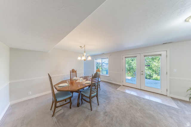 144 Bountiful Boulevard Bountiful, UT 84010 - Photo 26 of 28 Dining room with light colored carpet, hanging lights, french doors, and light tile patterned flooring