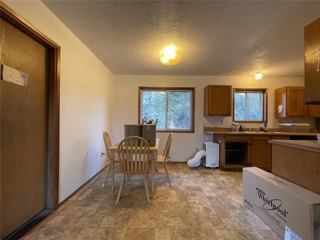a living room with furniture a fireplace and a open kitchen view