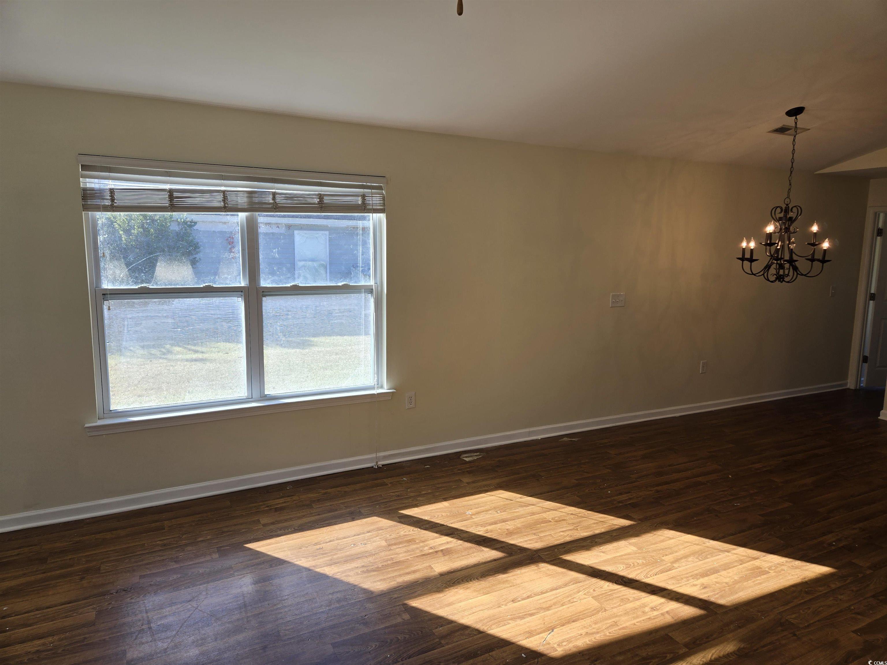1245 Pine Ridge Street Conway, SC 29527 - Photo 3 of 28 Spare room with dark wood-type flooring and a chandelier
