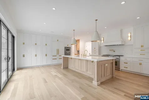a large kitchen with kitchen island a sink stainless steel appliances and cabinets