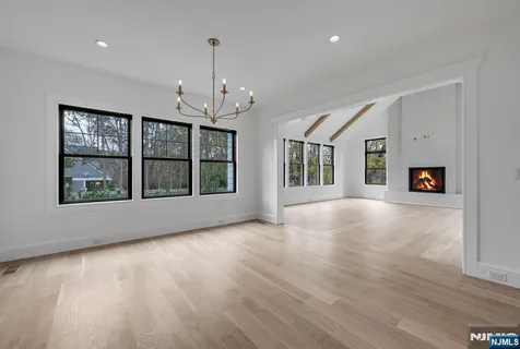 an empty room with windows and fireplace