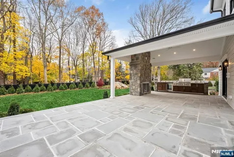 a view of a house with a big yard and large trees