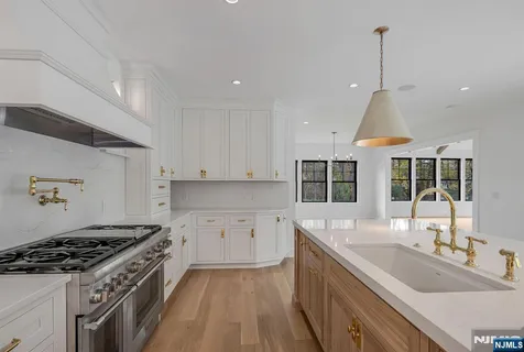 a kitchen with a sink stove top oven and cabinets