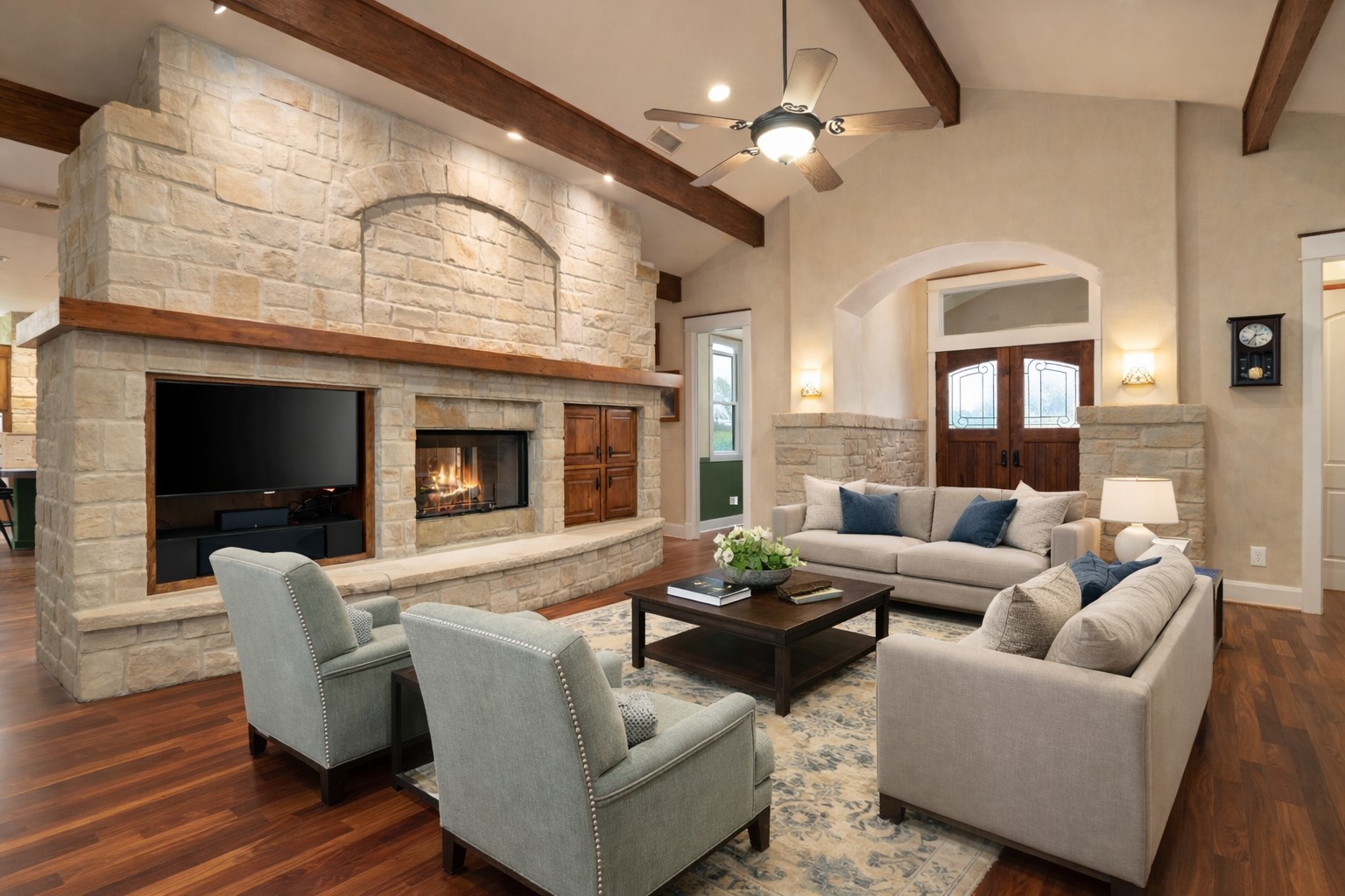 23426 Oscar Road Spicewood, TX 78669 - Photo 3 of 40 The living room's focal point is the incredible double-sided fireplace with built-ins. To the left are doors leading out to the large covered patio and lovely view. Virtually staged.